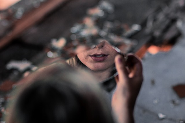 Zelfreflectie - deel gezicht in een gebroken spiegel