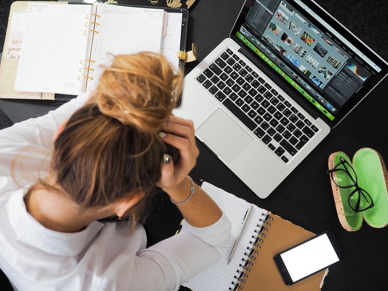 iemand gestresst boven laptop bij blog over stress door thuiswerken, tips voor thuiswerken