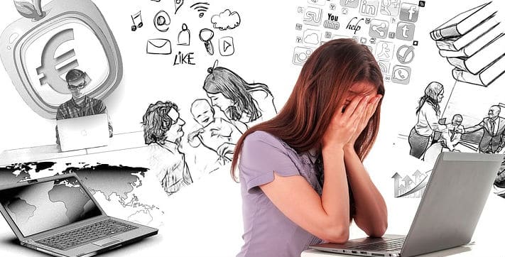Persoon met handen voor gezicht achter laptop bij blog over piekeren en stress